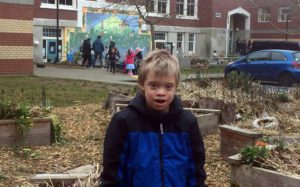 Sebastian, a young white boy stands in front of his school